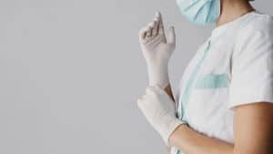 doctor-putting-on-surgical-gloves-with-copy-space